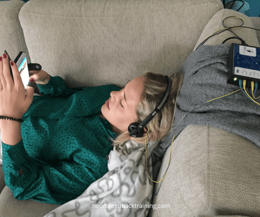 teenage girl using a phone during neuroptimal home session