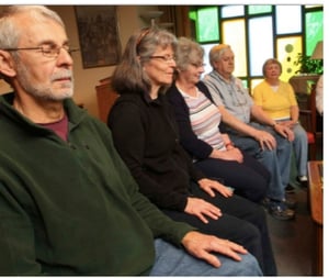 seniors meditating in chairs