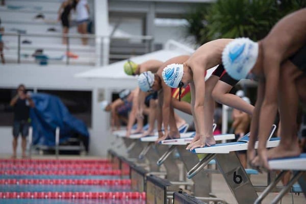 swimmers on blocks ready to perform at their best.