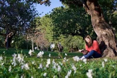 woman reading a book in park to destress